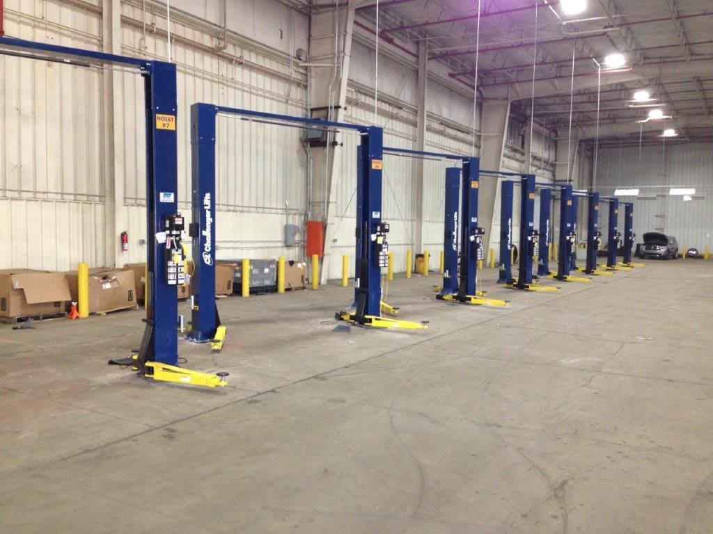 A line of blue lifts in an industrial setting.