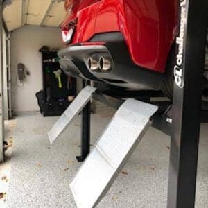 Red sports car elevated on garage lift